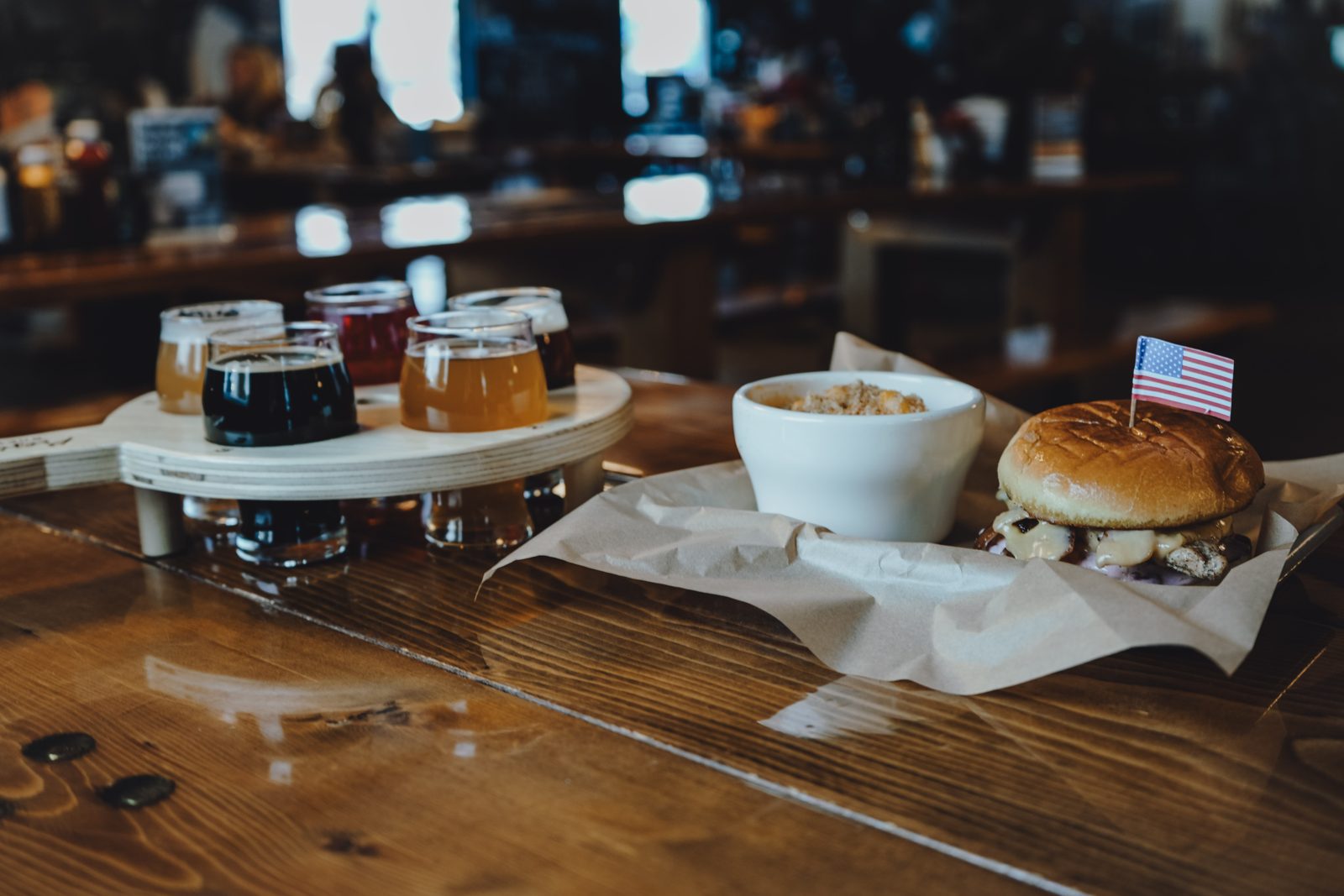 A burger beside a flight of Presidential craft beers at the bar