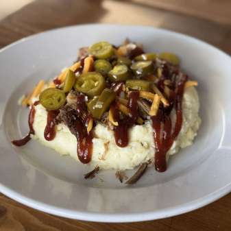 Mashed Potatoes, barbecue, pulled pork, pickled jalapenos, and shredded cheese.