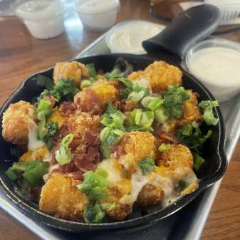 Tavern Tots - loaded tater tots with green onion, bacon, cheese, sour cream, and ranch